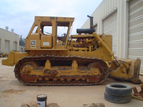 1966 International School Bus - A yellow Caterpillar D9-3 bulldozer is seen from the side, parked in an outdoor industrial area.