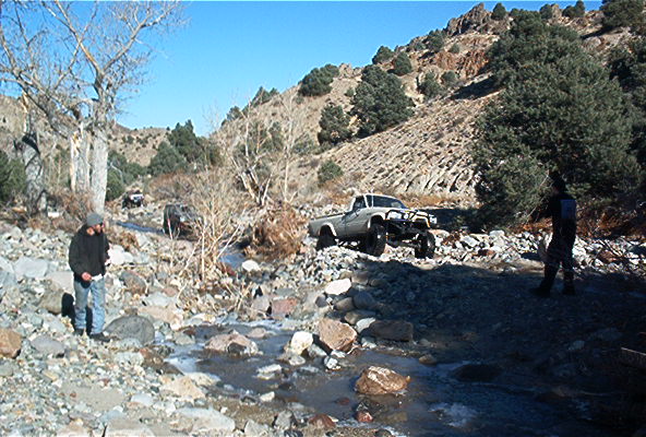 off-road pickup truck driving through rocky terrain