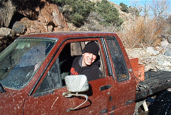Red pickup truck interior with driver, flatbed in rear