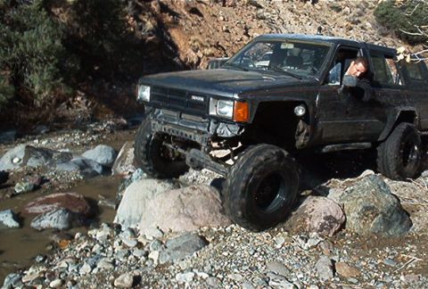 1986 Ford Bronco - This black Toyota 4Runner navigates a rocky stream bed during an off-road excursion.