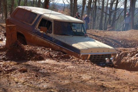 1992 Ford Mustang - A 1978 Ford Bronco is stuck deep in mud on an off-road trail.