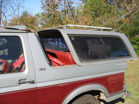 1986 Ford C-350 (Centurion Conversions) - Two-tone Ford Bronco with an open camper shell and roof rack.