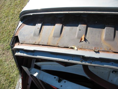 1986 Ford C-350 (Centurion Conversions) - Close-up of a rusted metal panel with raised ribs, likely a part of a vehicle's body.