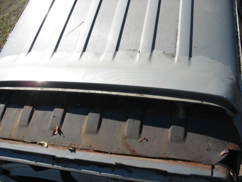1986 Ford C-350 (Centurion Conversions) - The top of a vehicle shows a ribbed roof section and a dark gutter with leaves and rust.