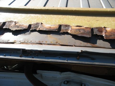 1986 Ford C-350 (Centurion Conversions) - The corroded metal panel shows significant damage and rust, indicating a need for repair.