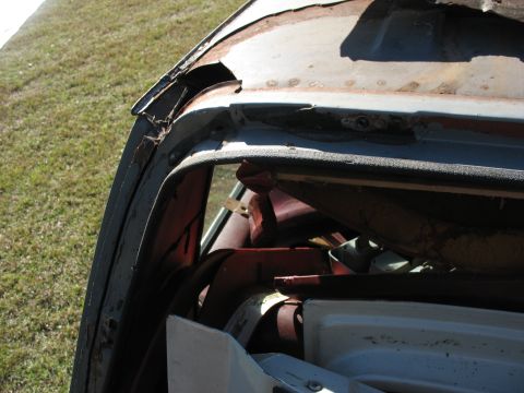1986 Ford C-350 (Centurion Conversions) - Close-up view of the damaged roofline and interior components of a vehicle, showing significant rust and wear.