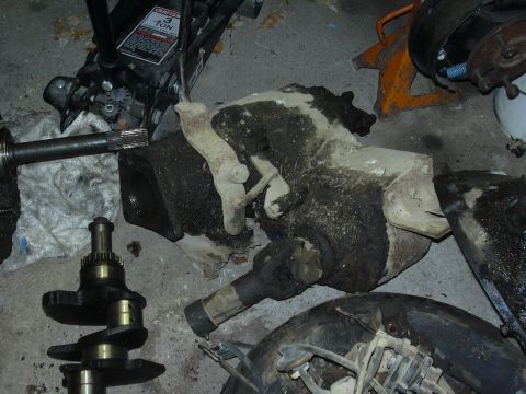 1996 Ford Crown Victoria - Various engine and drivetrain components are laid out on the floor, including a crankshaft and a differential housing.