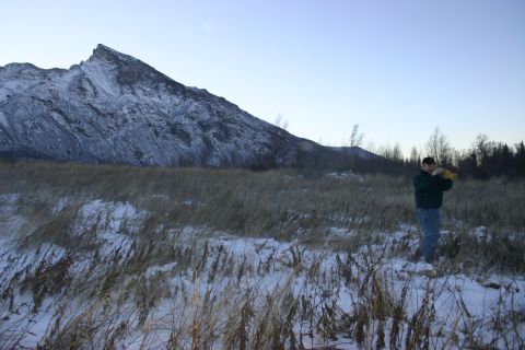 2003 Jeep TJ - A man stands in a snowy field with a mountain range behind him.