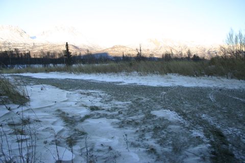 2003 Jeep TJ - A winter scene with snow-covered ground and dry grass, set against a backdrop of distant mountains.
