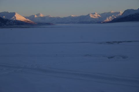 2003 Jeep TJ - A vast, snow-covered landscape is illuminated by the soft light of sunrise, with distant mountains forming a backdrop.