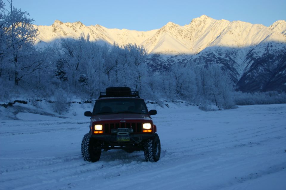 Red Jeep Cherokee XJ in snow with winch and roof rack