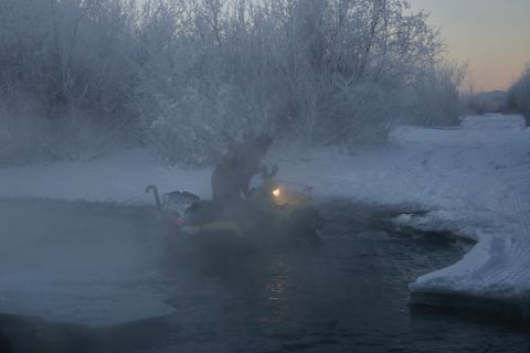 2003 Jeep TJ - Snowmobile navigates through icy water amidst a frosty winter landscape.