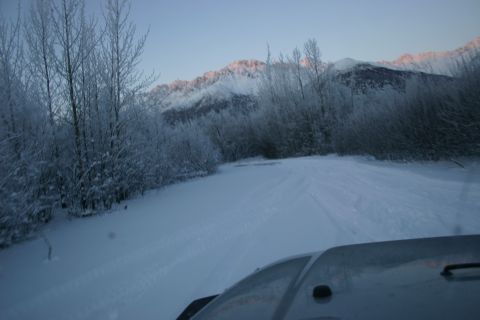 2003 Jeep TJ - Driving through a snowy landscape with mountains in the background during sunrise.