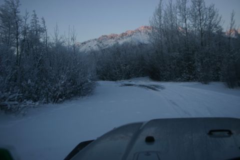 2003 Jeep TJ - Driving through a snowy landscape with frosted trees and a sunlit mountain range ahead.