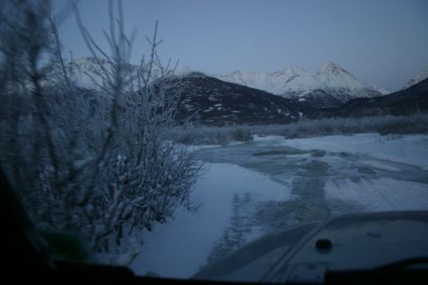 2003 Jeep TJ - Driving through a snowy landscape with mountains in the background during twilight.