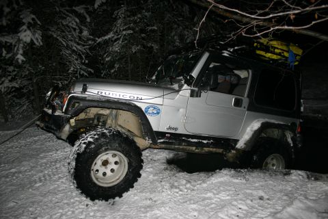2003 Jeep TJ - Silver 2003 Jeep Wrangler Rubicon with a roof rack is stuck in the snow during a winter excursion.