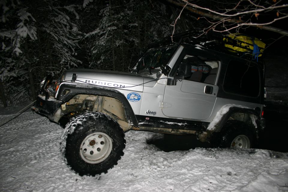 Silver 2003 Jeep Wrangler Rubicon with roof rack in snow