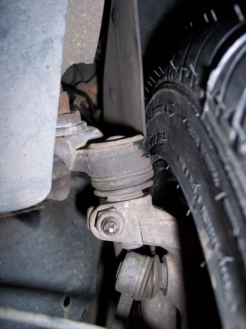 2001 Ford Crown Victoria - Close-up view of a vehicle's suspension system and tire, with a website logo visible.