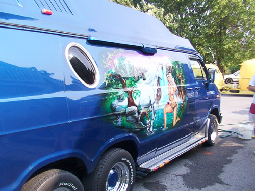 Blue custom van with mural art, side view, dual rear wheels