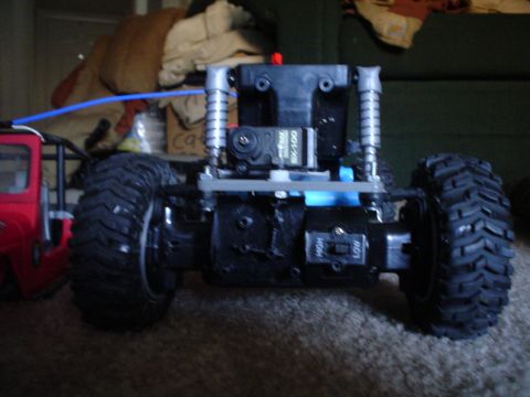 2006 Jeep TJ - RC car chassis with large tires and a red body section visible on the left.