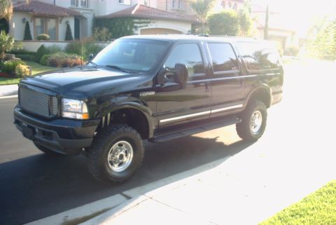 2001 Ford Excursion - Lifted black Ford Excursion SUV seen from a 3/4 front angle on a sunny day.