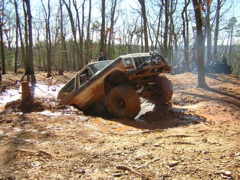 1979 Ford Bronco - A heavily modified 1978 Ford Bronco navigates a challenging muddy terrain during an off-road event.