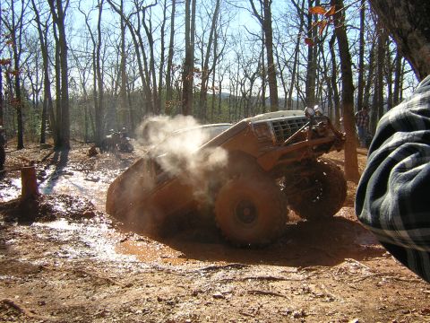 1979 Ford Bronco - Muddy off-road event shows a 1979 Ford Bronco struggling in a mud pit.