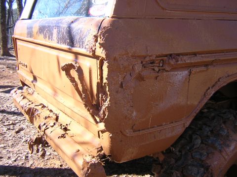 1979 Ford Bronco - This heavily mud-caked vehicle's rear quarter panel and bumper are visible, obscuring any identifying details.