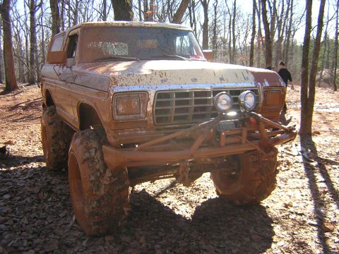 1979 Ford Bronco - This heavily modified Ford Bronco is covered in mud after an off-road excursion in a wooded area.