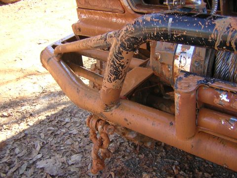 1979 Ford Bronco - This heavily mud-caked vehicle features a robust front bumper and winch, suggesting off-road use.