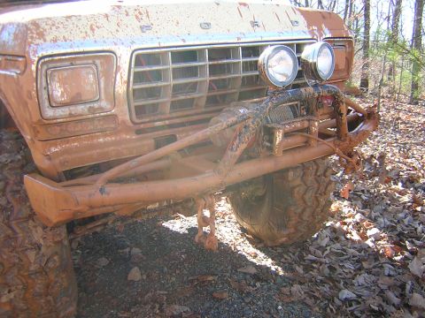 1979 Ford Bronco - The grille and headlight design strongly suggest a 1979 Ford Bronco, despite the heavy mud coating.