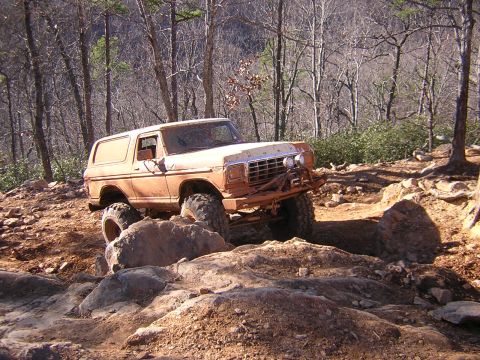 1979 Ford Bronco - This modified SUV navigates a rocky trail in a wooded area.