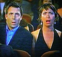 1996 Ford Probe - A man and woman in a theater audience react with surprise to something happening on stage.