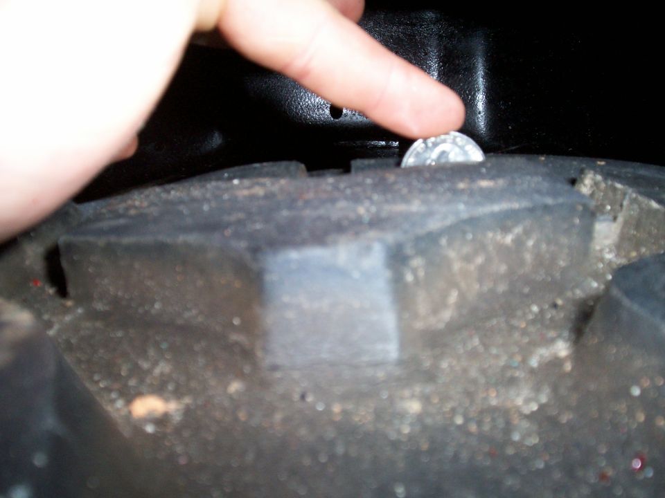 Close-up of tire tread with a quarter for scale