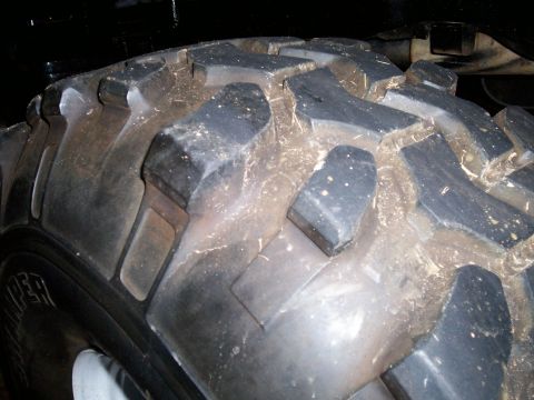 1974 Ford F-100 - This image shows a close-up of a off-road tire, likely from a truck or SUV, with visible tread and some dirt clinging to it.