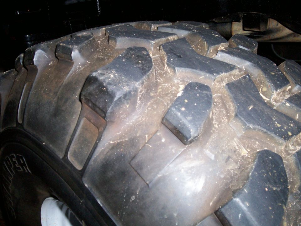Close-up of a large, knobby off-road tire with mud on it