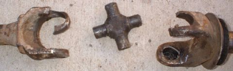 1993 Ford Bronco - Close-up of damaged driveshaft universal joints and a cross spider joint, indicating mechanical failure.