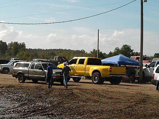 Yellow Ford F-350 Super Duty pickup truck, crew cab, dually rear wheels, parked on dirt