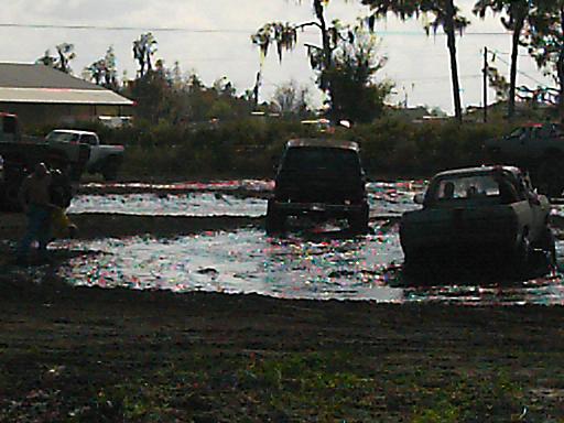Mud bog event with several trucks stuck in the mud