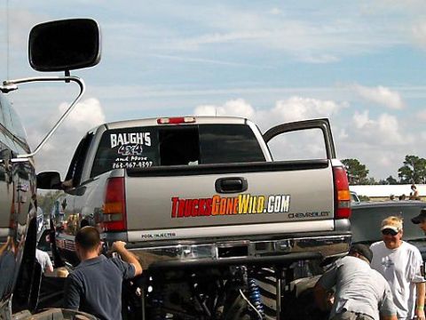 1986 Ford Bronco - Silver pickup truck with custom decals and an open driver's door.