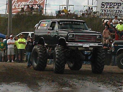 1986 Ford Bronco - A modified 1986 Ford Bronco, also known as a monster truck, sits on massive tires at an event.