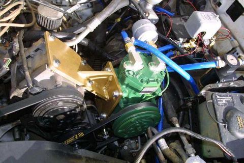 1993 Ford Bronco - An on-board air setup in an engine bay: a green-painted York-style compressor with a breather filter, mounted on a gold anodized billet bra…