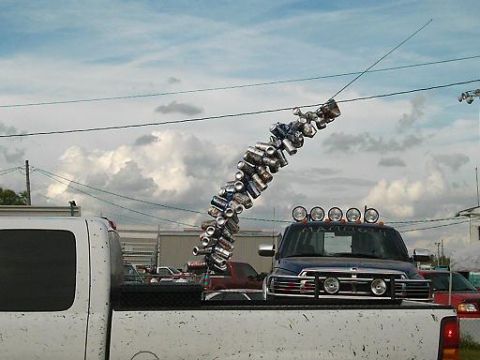 1986 Ford Bronco - A blue pickup truck is decorated with a string of cans hanging from its antenna.