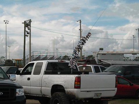 1986 Ford Bronco - A modified pickup truck is parked at an outdoor event with a unique antenna decoration.