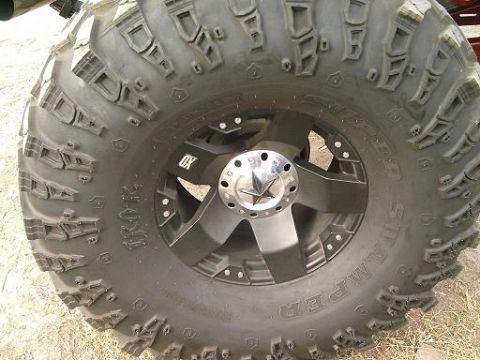 1986 Ford Bronco - Custom wheel and aggressive off-road tire mounted on a vehicle.