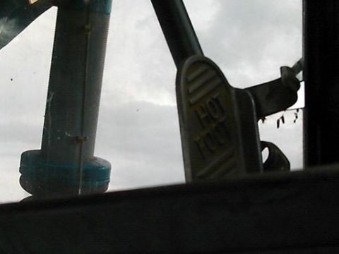 1986 Ford Bronco - Interior shot of a vehicle's 'HOT FOOT' lever against a cloudy sky.