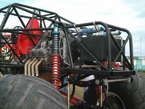 1986 Ford Bronco - Custom monster truck engine and suspension details with a large tire visible.