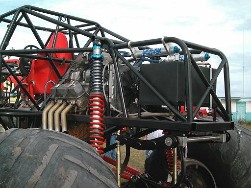 Monster truck V8 engine with custom roll cage, dual shocks, and large tire