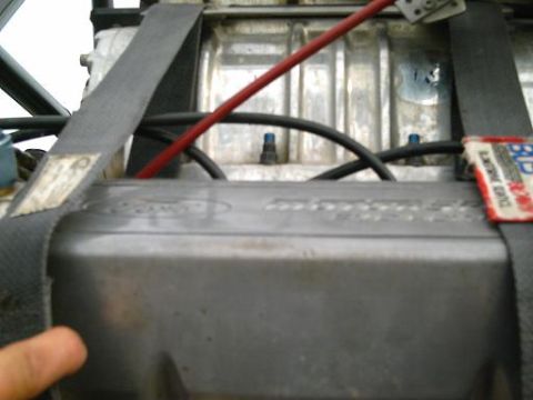 1986 Ford Bronco - Close-up of an engine bay, a racing harness and various hoses.