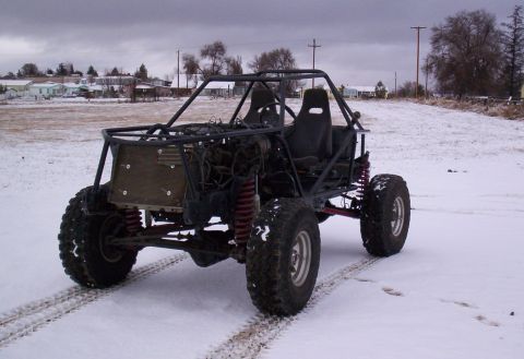 1984 Ford Bronco - Custom off-road buggy with roll cage and exposed engine sits in a snowy field.